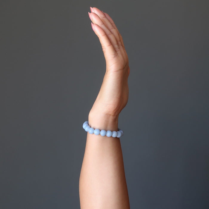 hand wearing blue angelite round beaded stretch bracelet