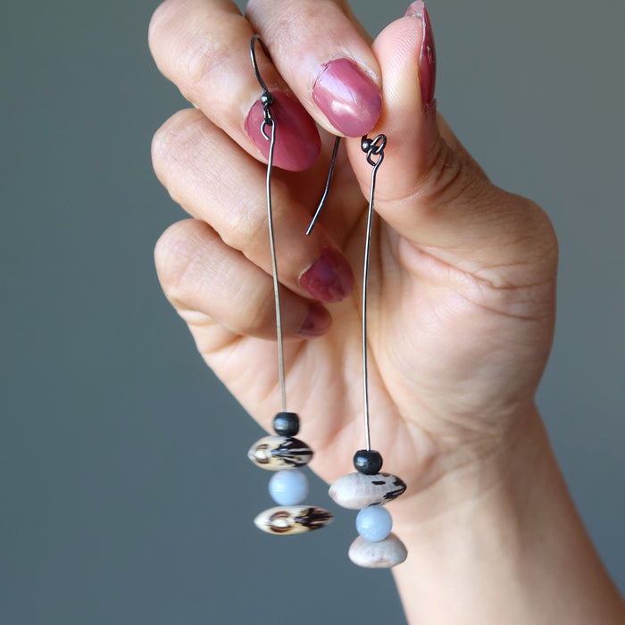 holding angelite Hopi bean and wood bead dangling earrings