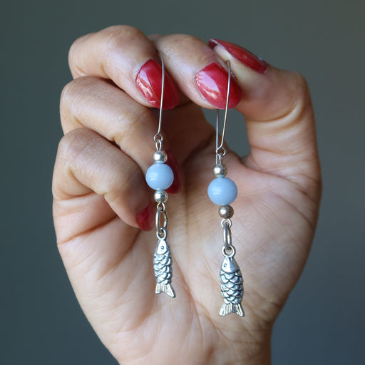 hands holding blue angelite fish earrings
