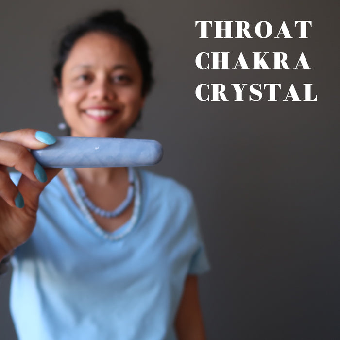 sheila holding a blue angelite massage wand at the throat chakra
