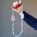holding 25 x 1.3 inch round bead Angelite and Red Marble Necklace