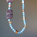 displaying part of 25 x 1.3 inch round bead Angelite and Red Marble Necklace