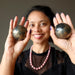 sheila of satin crystals holding two apache gold spheres in her palms