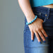 woman hand in jeans pocket wearing  blue apatite gemstone stretch bracelet