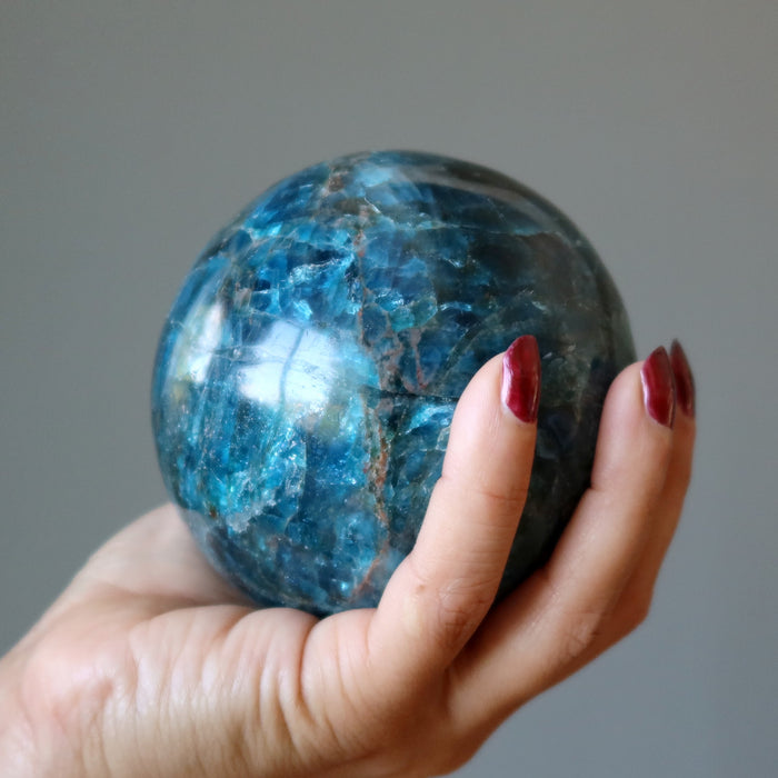 hand holding up an apatite sphere