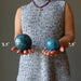woman holding two apatite spheres to show size difference