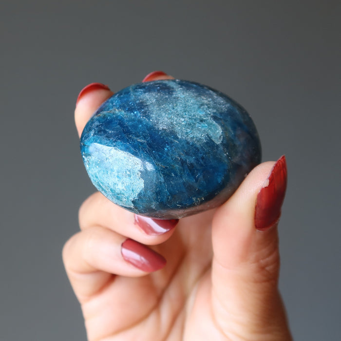 hand holding rocky blue apatite palm stone
