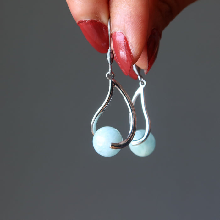 hand holding aquamarine earrings
