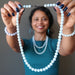 sheila of satin crystals holding out a blue aquamarine necklace