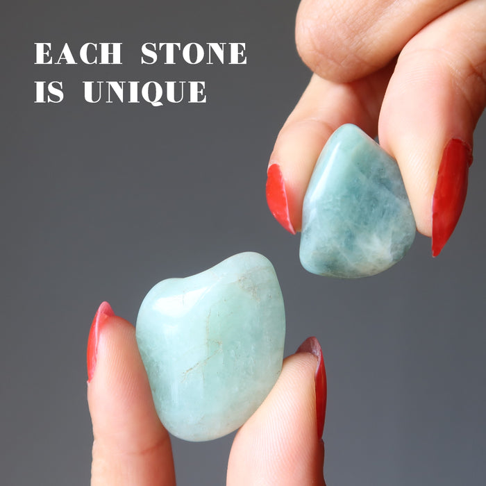 hand holding aquamarine tumbled stones