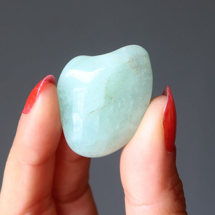 hand holding aquamarine tumbled stone