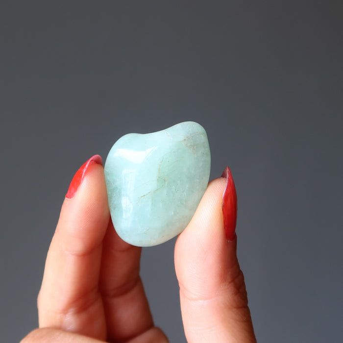 hand holding aquamarine tumbled stone