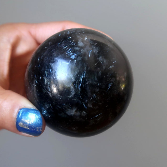 hand holding arfvedsonite sphere