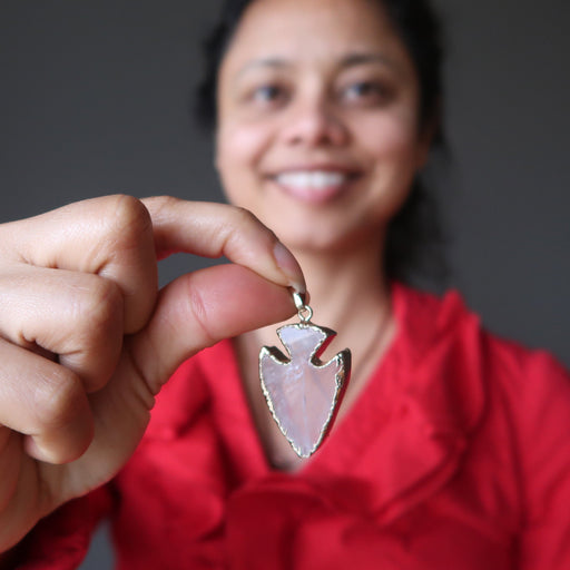sheila of satin crystals holding a rose quartz arrowhead pendant