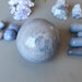 blue aventurine sphere surrounded by blue stones and flowers