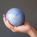 hands holding a blue aventurine sphere