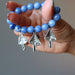 hand holding blue aventurine mushroom stretch bracelet showing the back
