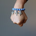 female hand making a downward fist wearing blue aventurine mushroom stretch bracelet