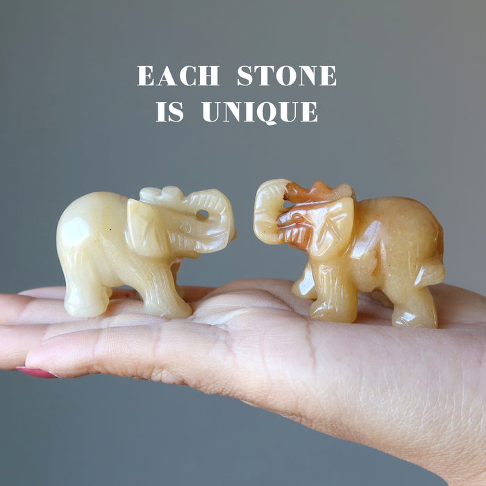 two Golden Aventurine Elephant Figurines on model palm