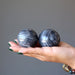hand holding 2 gray and white aventurine spheres