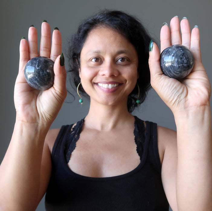 sheila of satin crystals holding gray and white aventurine spheres in her palms