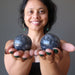 sheila of satin crystals holding gray and white aventurine spheres in her palms