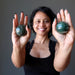 sheila of satin crystals holding green and white streaked aventurine spheres in her palms