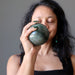 sheila of satin crystals meditating with a green aventurine sphere in the palm of her hands