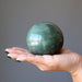 hand holding green aventurine sphere