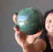 sheila of satin crystals holding a green aventurine sphere