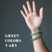 hand modeling two green aventurine beaded stretch bracelet to show green colors vary