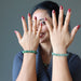 female modeling two green aventurine beaded stretch bracelets