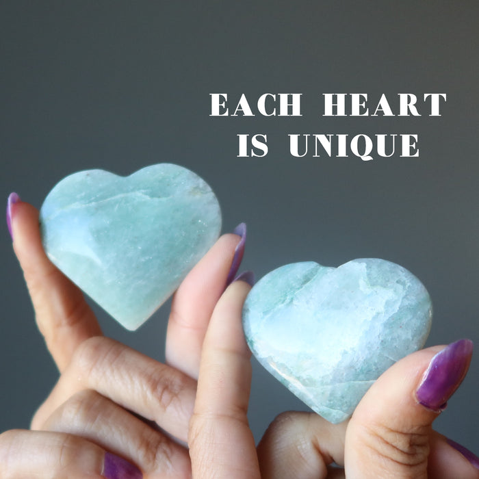 two hands holding aventurine hearts to show each is unique