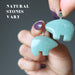 hand holding aventurine bear pendants to show natural stones vary