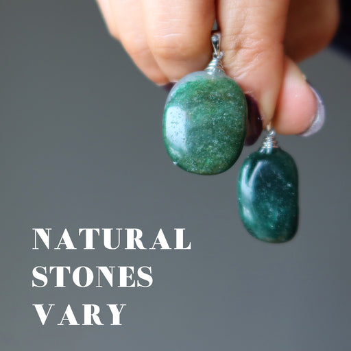 hand holding two dark green aventurine pendants to show natural stones vary