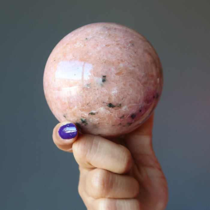hand holding pink aventurine sphere