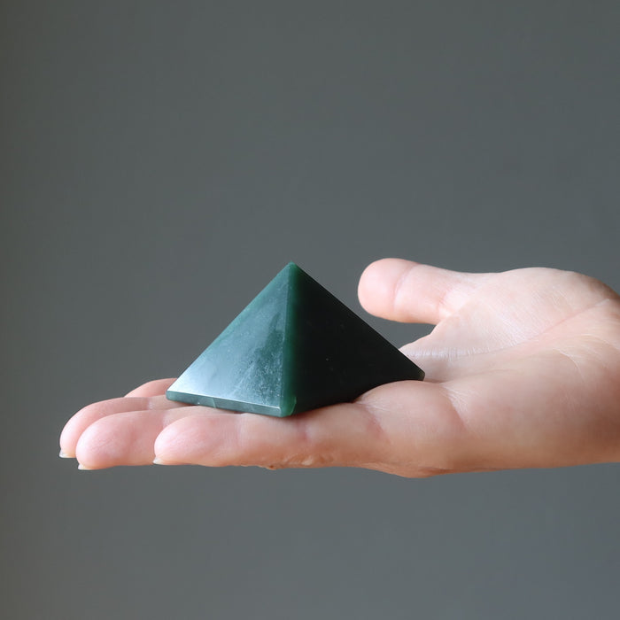 hand holding dark green aventurine pyramid