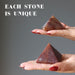 hands holding red aventurine pyramids to show each is unique