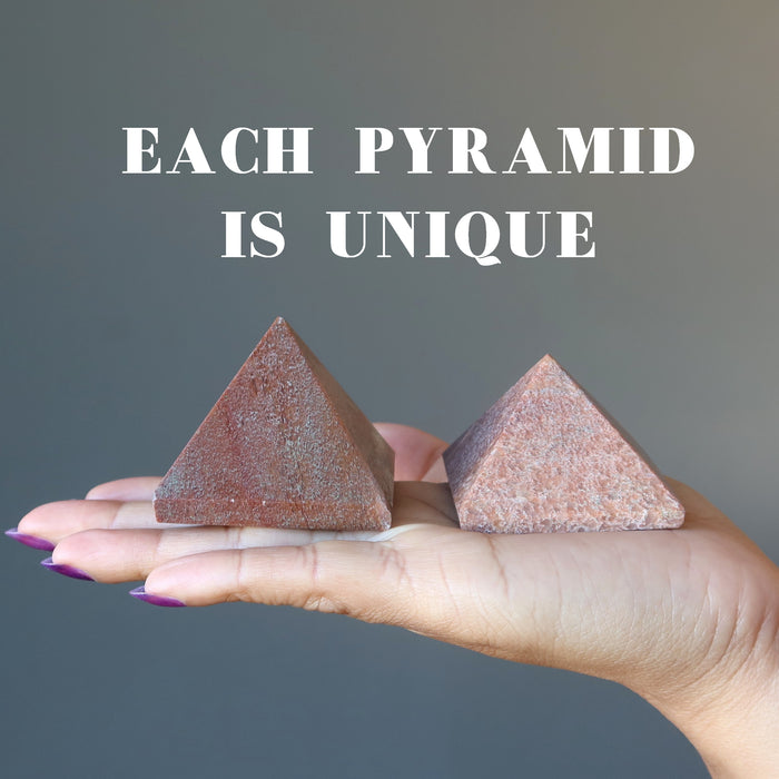 hand holding two pink aventurine pyramid