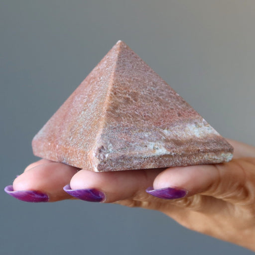 hand holding pink aventurine pyramid