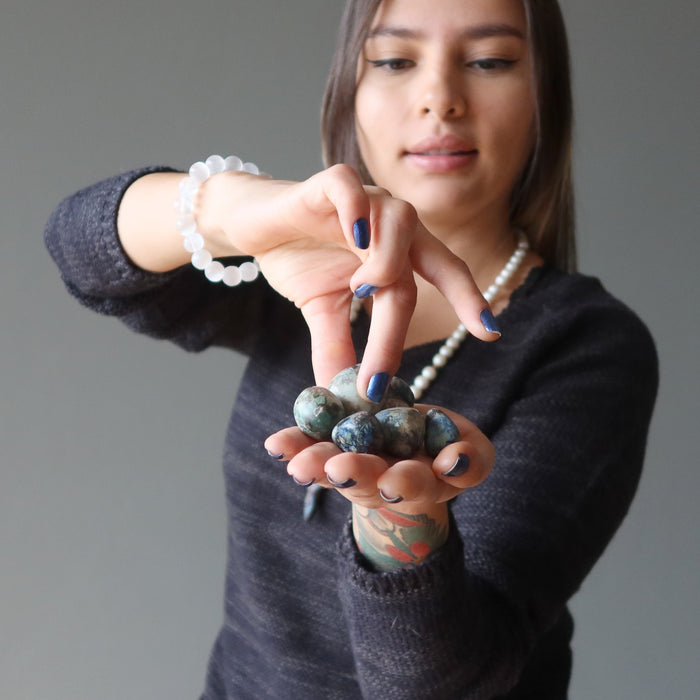 woman picking out azurite tumbled stones