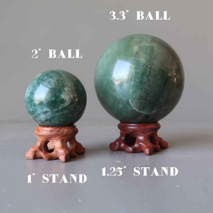 two green aventurine spheres on brown pedestal display stands in varying sizes