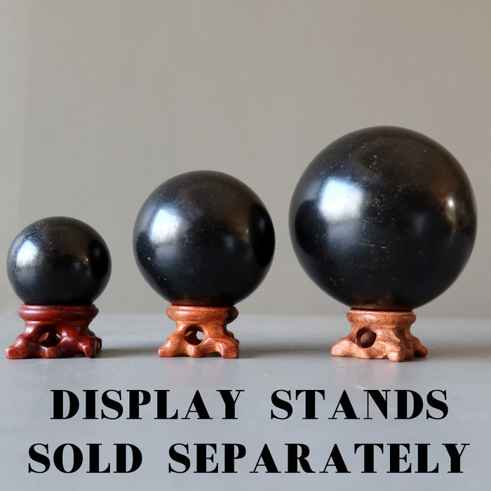 3 basalt lava spheres on fancy wood stands, which are sold separately