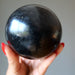 hand holding a black basalt sphere