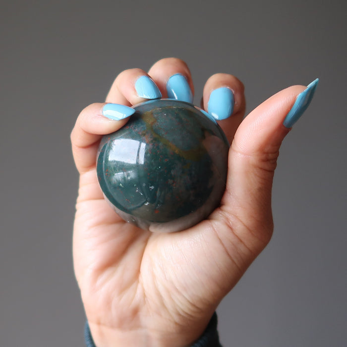 hand holding an indian bloodstone sphere