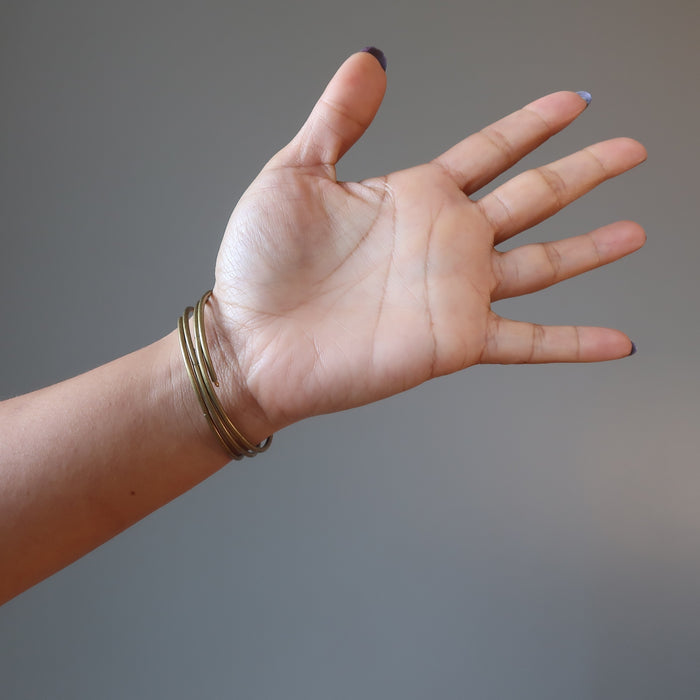 female hand wearing bloodstone coil bracelet