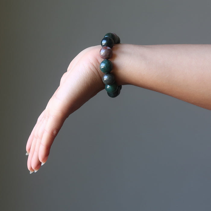 female hand  wearing bloodstone bracelets