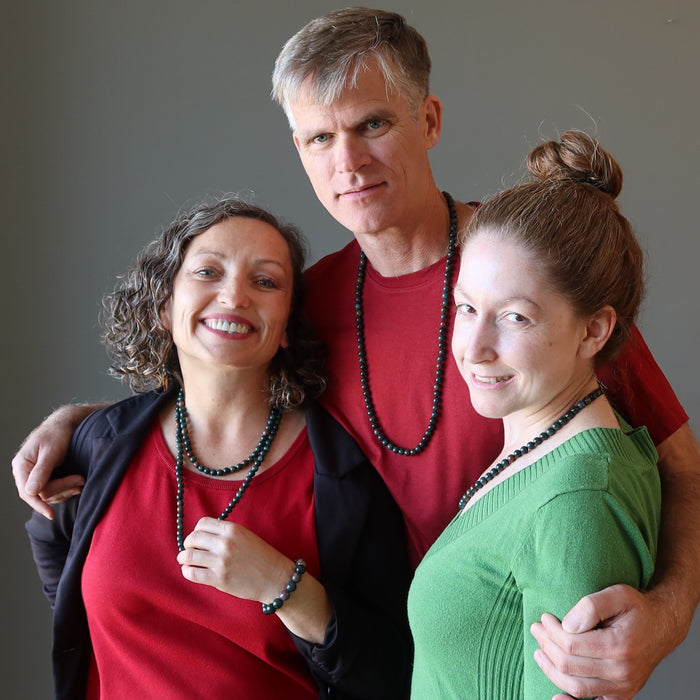 male and two females wearing female wearing bloodstone necklace
