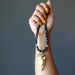 hand holding gold arrowhead bloodstone beaded necklace