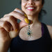 sheila of satin crystals holding a bloodstone sun pendant in front of her chest